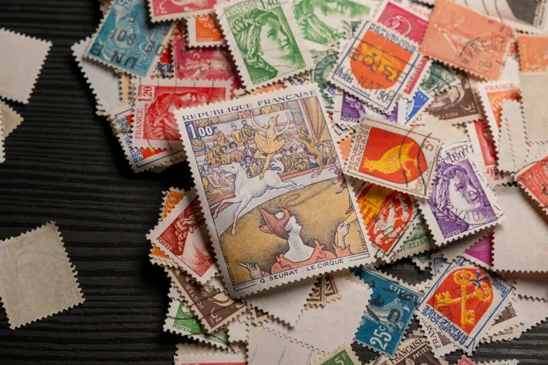 Old French stamps scattered on dark wood