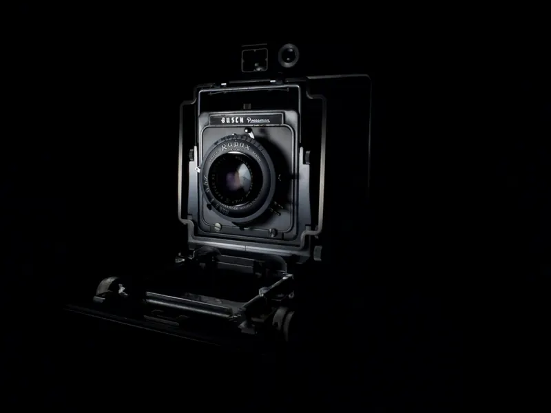 Camera with a large lens against a black background