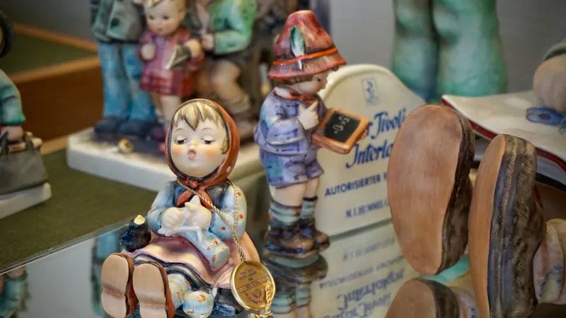 Porcelain figures of children on a reflective surface