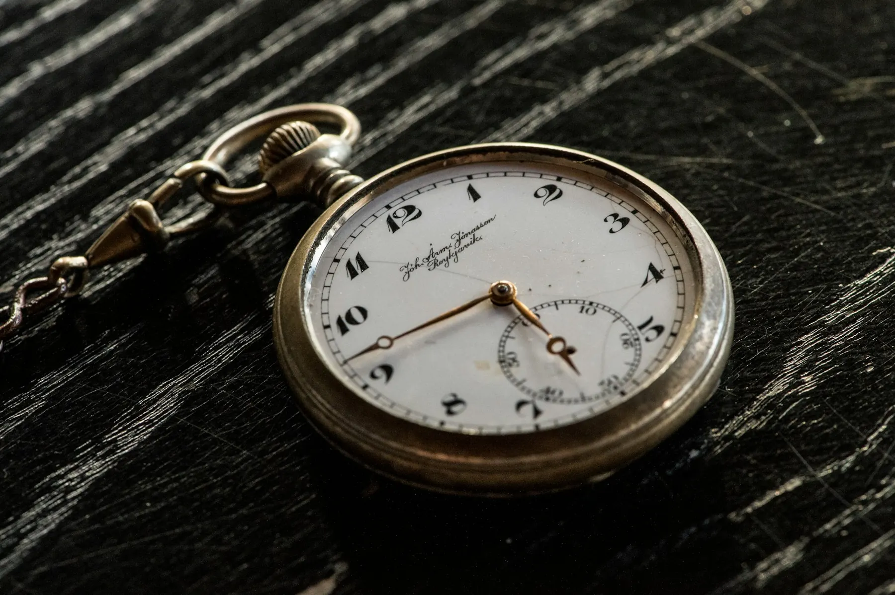 Montre de poche avec chaîne sur bois sombre